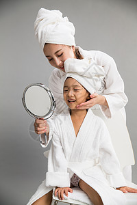 亲情健康生活方式拿着穿着浴袍的母女照镜子图片