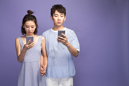 彩色图片背景分离摄影各自玩手机的青年情侣图片