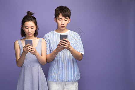 水平构图青年伴侣生气各自玩手机的青年情侣图片