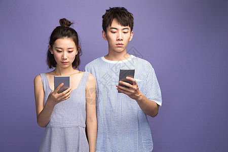专心沟通男各自玩手机的青年情侣图片