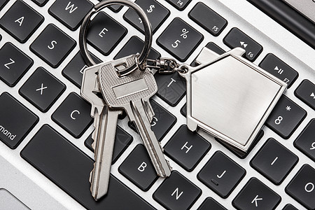 科技钥匙安全住房问题英文字母键盘上的钥匙与吊饰背景