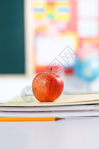 学习课桌教科书苹果放在书本上背景图片