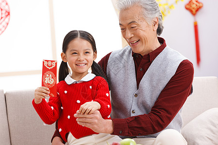 坐着微笑户内小女孩和爷爷过新年高清图片