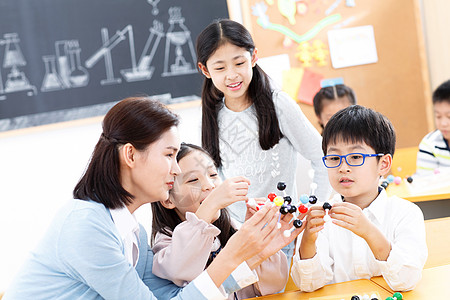 自由学习女教师和小学生在教室里背景