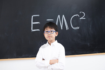 在校生8岁到9岁聪明小学男生站在黑板前图片