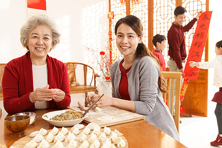 老年人夫妇注视镜头幸福家庭过年包饺子图片