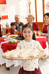 春节元素庆祝儿童兴奋小女孩过年端着饺子背景