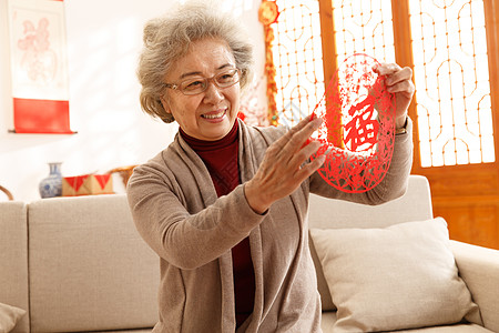 贴福字老人人家庭生活福字老年人过年贴窗花背景