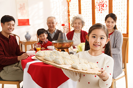 冬至祝福元素正面视角兴奋小女孩过年端着饺子背景