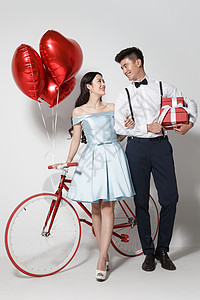 浪漫情侣系着心形气球的礼物盒高清图片