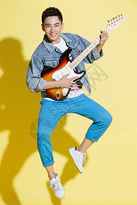 注视镜头时尚简单背景青年男人弹吉他图片