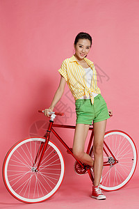 摄影短裤活力青年女人斜靠着自行车图片