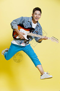 酷休闲装黄色背景青年男人弹吉他图片