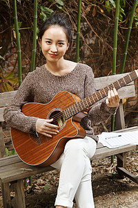 业余爱好快乐的年轻女人弹吉他图片