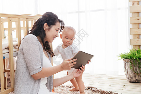 年轻妈妈和宝宝看平板电脑图片