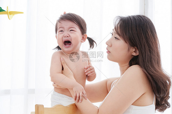 年轻妈妈安抚哭泣的宝宝图片