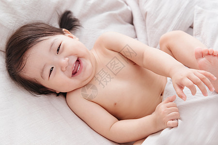 幸福好奇心欢乐可爱宝宝躺在床上图片