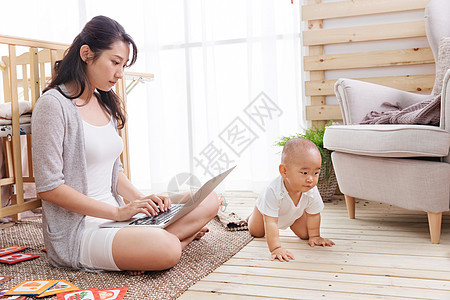 互联网笔记本电脑两个人年轻妈妈在家边看孩子边使用电脑图片