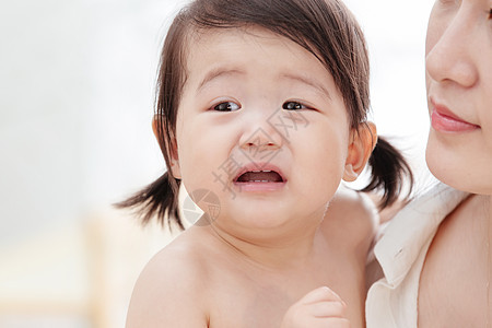 亚洲彩色图片不高兴的年轻妈妈抱着哭着的宝宝图片