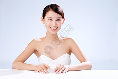 东方人摄影魅力年轻美女拿着润肤霜背景图片