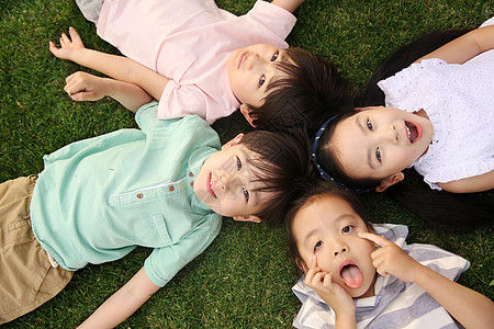 童年休闲装做鬼脸快乐的孩子们在草地上玩耍图片