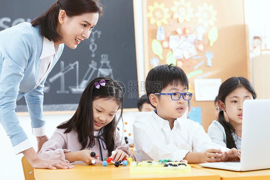 女教师和小学生在教室里使用电脑图片