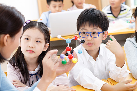 一群女生学校教师和小学生在教室里上课背景