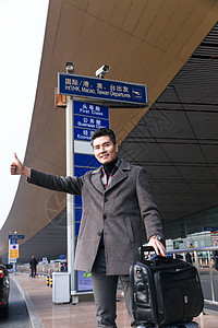 亚洲挥手便捷商务男人在机场打车图片