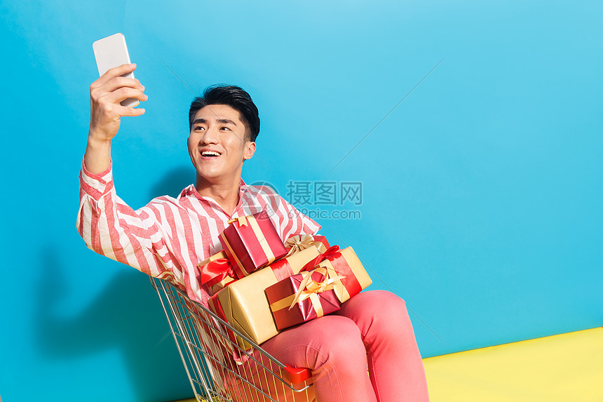 人自拍东亚拿着礼品盒的青年男人看手机图片