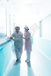身体关注放松制服护士和老年男人在医院走廊图片