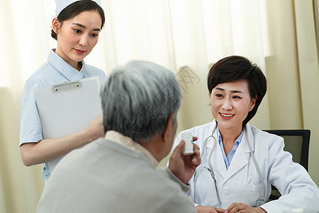 亚洲满意病历卡医务工作者和患者在医生办公室高清图片