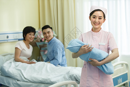 医疗用品青年女人包裹护士和新生儿的父母图片