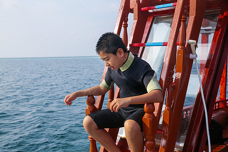 旅游目的地船零件旅途男孩在船上高清图片