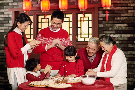 中式全家福年夜饭老年女人全家福幸福家庭过年包饺子背景