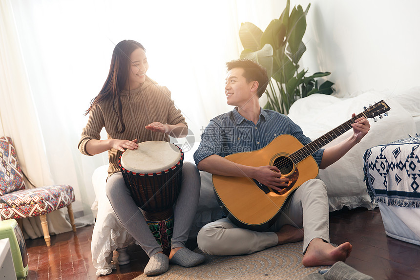 青年伴侣住宅内部弹奏快乐情侣在家演奏乐器图片