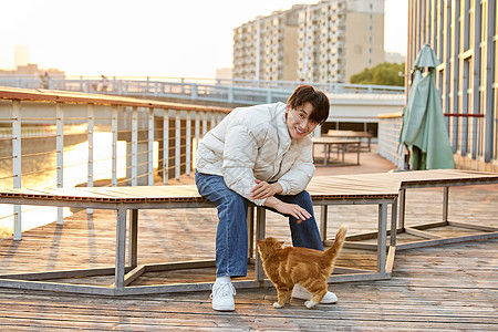 猫冬天秋冬男性室外与猫咪互动背景