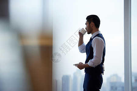 商务精英喝咖啡站在窗前喝咖啡的精致男士背景