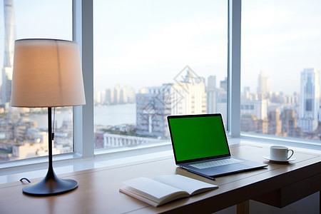 窗台边桌子上的电脑和笔记本图片