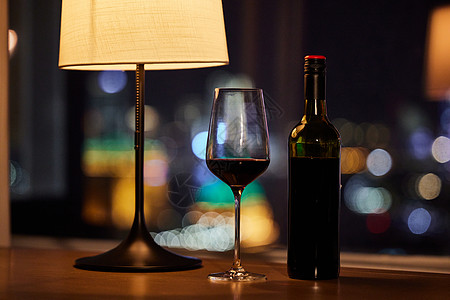 夜晚窗台边摆放的红酒图片
