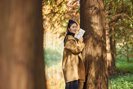 秋季户外美女公园看书高清图片