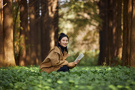 森林中的美女公主秋季美女森林中看书背景