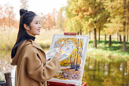 年轻女性秋季公园写生背景图片