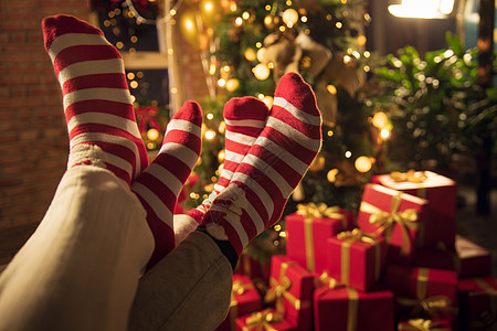 青年男人愉悦节日穿着圣诞情侣袜的脚部特写图片