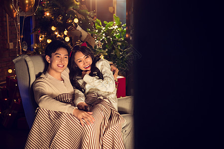 圣诞节头饰户内幸福甜蜜的年轻伴侣坐在沙发上图片