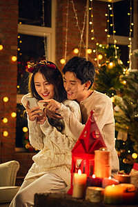 休闲活动传统节日帅哥幸福的年轻伴侣在家玩手机图片