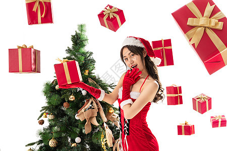 飘落帽子圣诞树穿着圣诞服的年轻女人和圣诞礼物图片