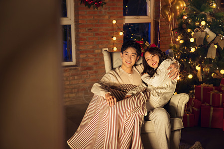 男人舒服圣诞节幸福甜蜜的年轻伴侣坐在沙发上高清图片