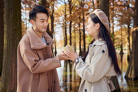 秋冬青年情侣公园郊游男生送女生礼物图片