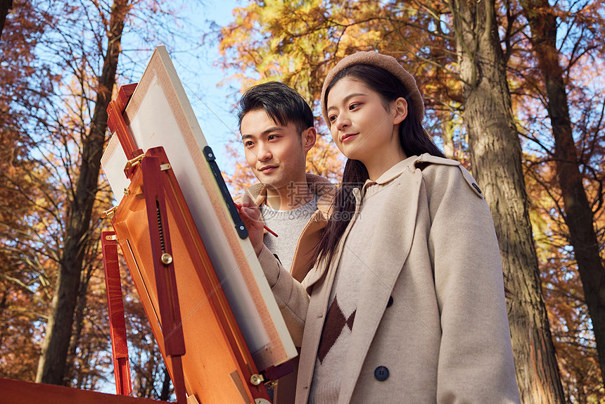 秋季户外情侣在公园里画油画图片