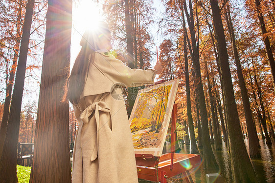 秋冬美女户外森林里作画图片